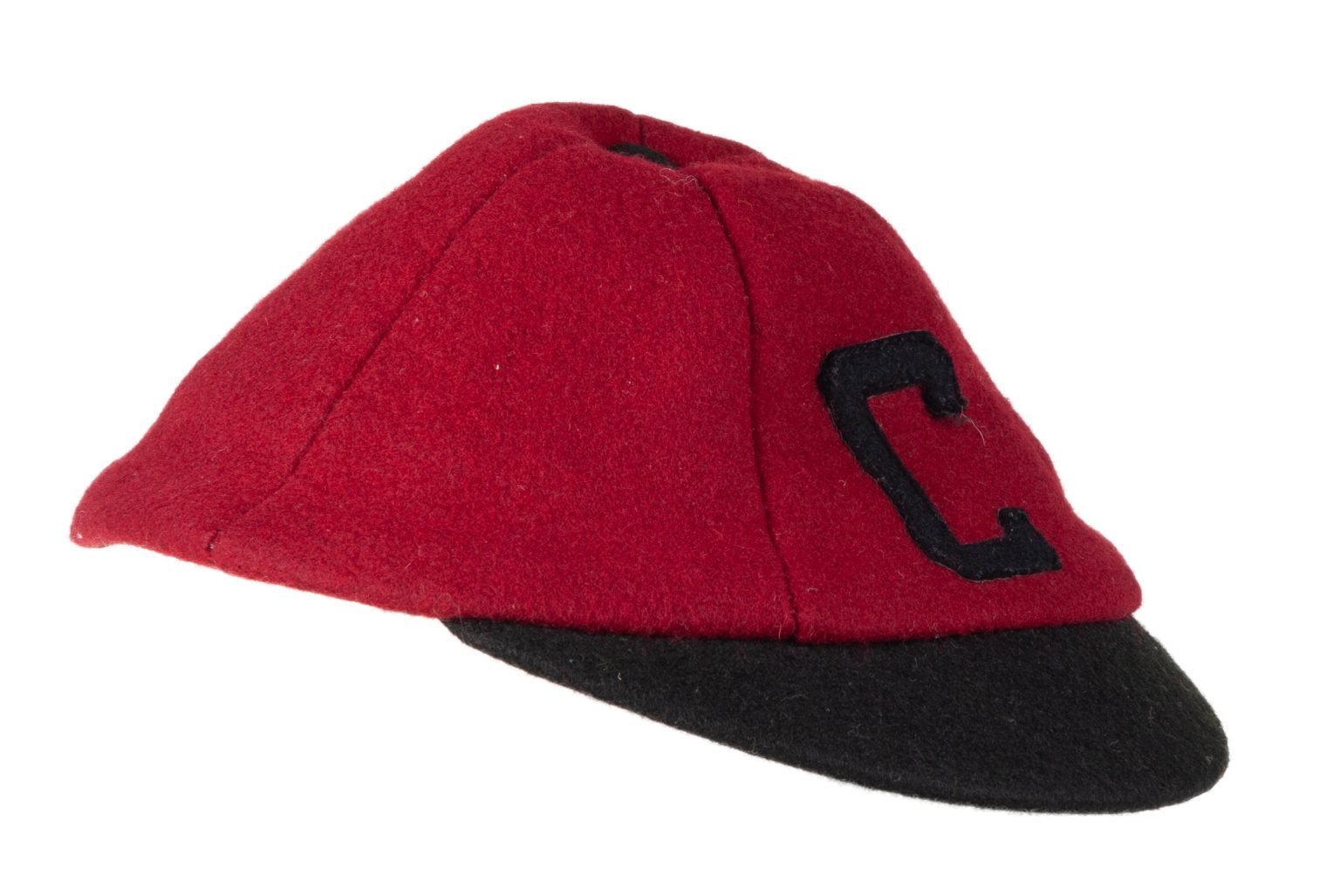 Round beanie with short bill. The cap is made of garnet wool and has a black capital letter "C" sewn on front in black wool. Bill is made of black wool. Inside is lined with brown cardboard to keep shape of hat. Small metal button at crown of beanie covered with black felt on outside. The initials "ML" are written on right side inside on cardboard in black pen.